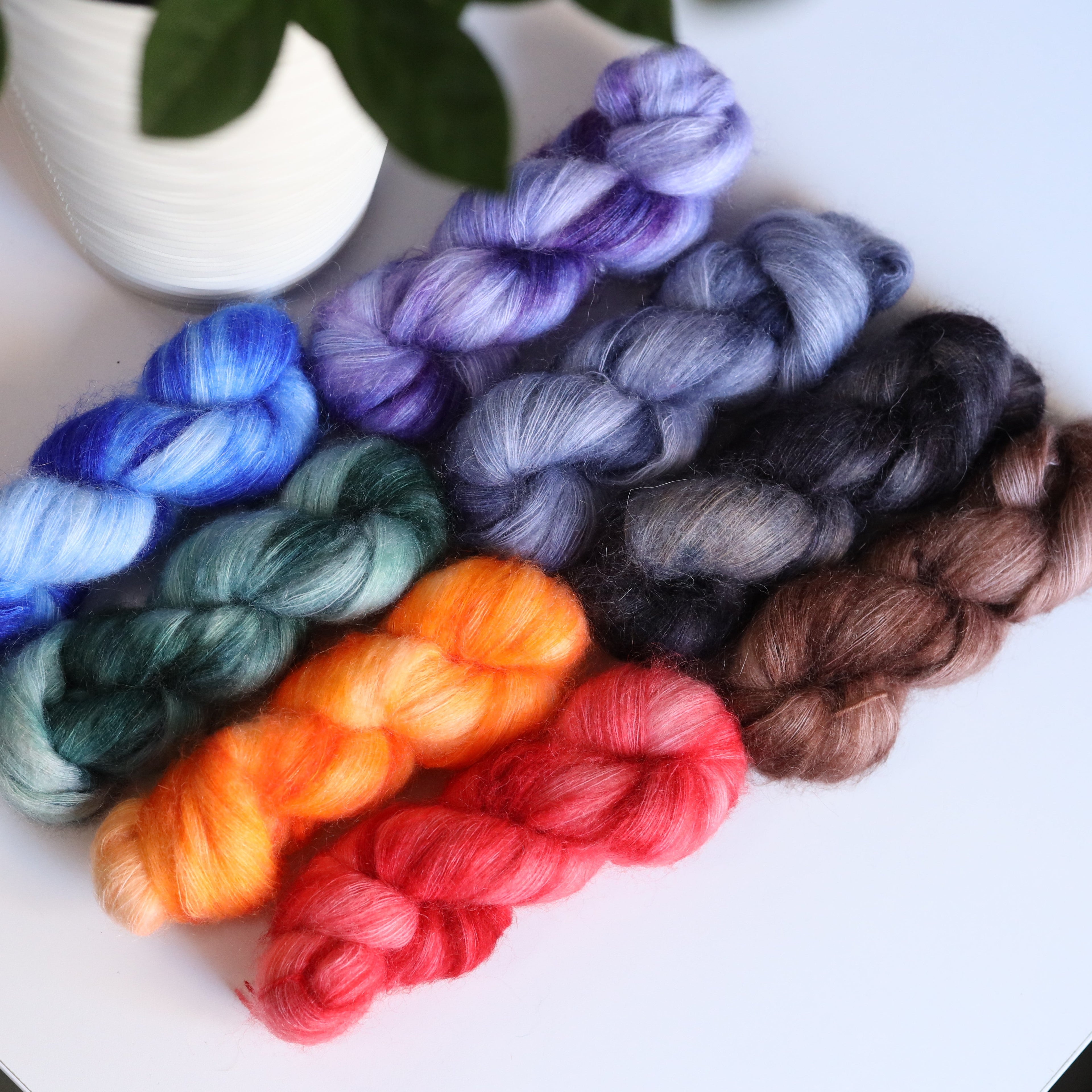 Hand dyed mohair nylon yarn skeins in bright variegated colors with soft fluffy halo texture for knitting and crochet projects
