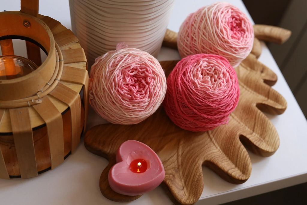 Hand dyed pink gradient merino wool yarn cakes in blush, rose, and soft pink shades, 100% merino wool DK weight yarn for knitting and crochet.