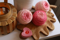Hand dyed pink gradient merino wool yarn cakes in blush, rose, and soft pink shades, 100% merino wool DK weight yarn for knitting and crochet.