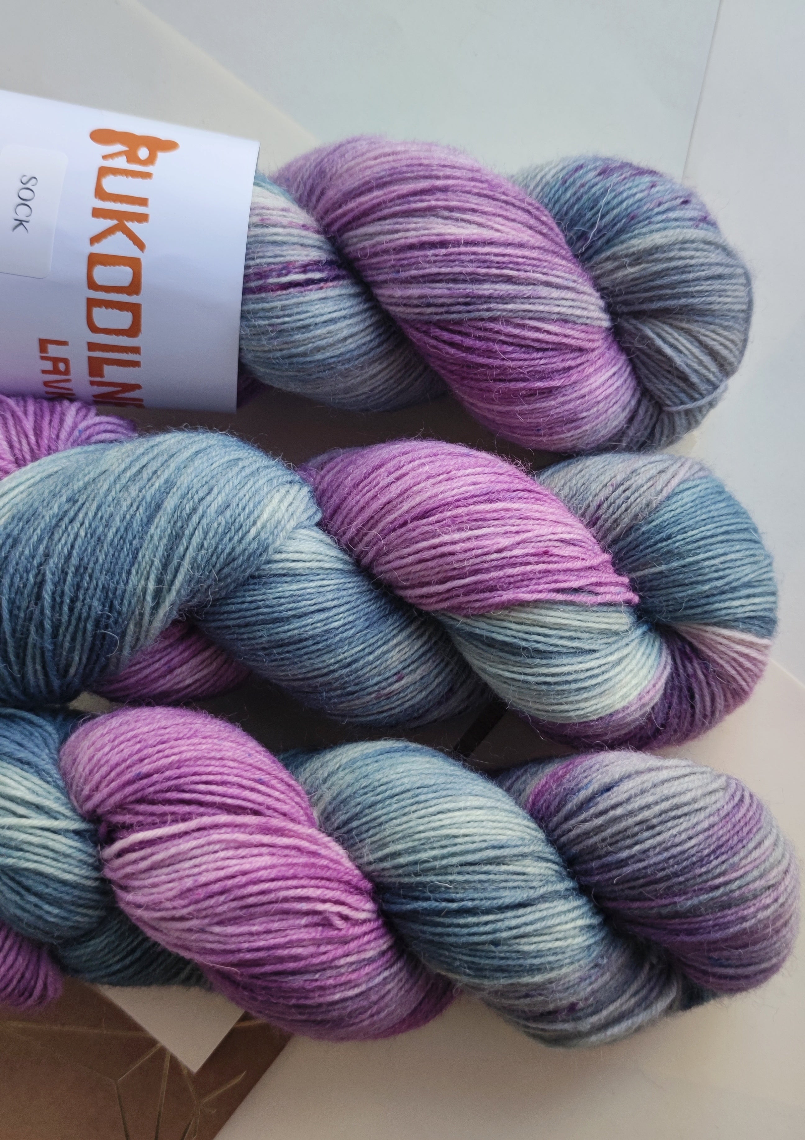 Hand dyed sock yarn in soft lavender and sage tones, made from superwash merino wool and nylon, ideal for knitting socks, shawls, and everyday knitwear.