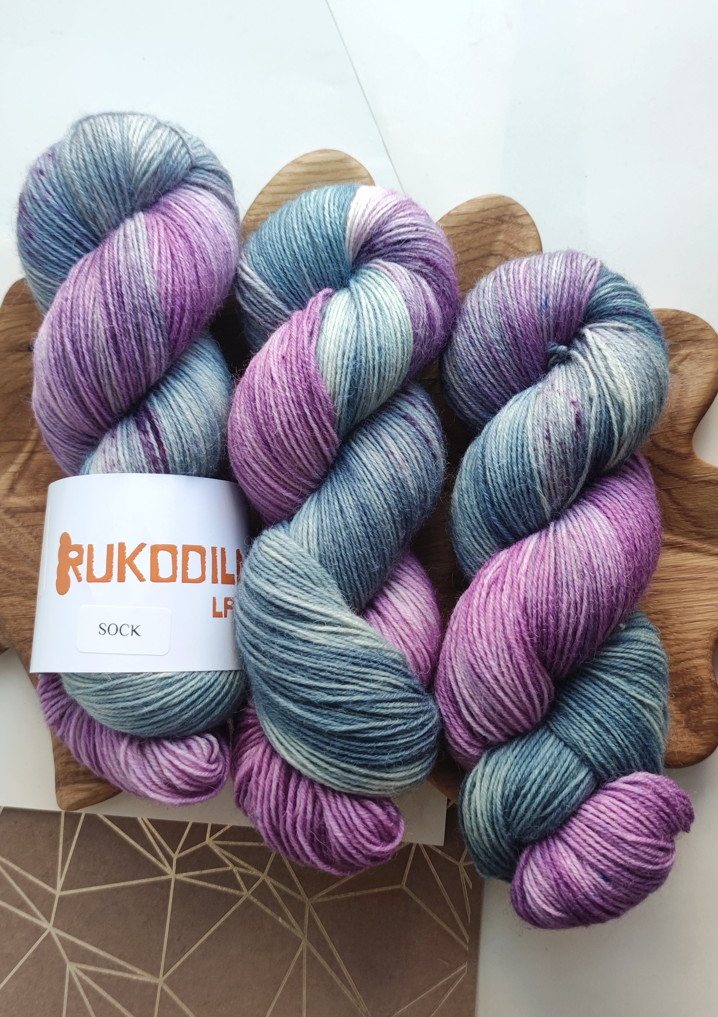 Hand dyed sock yarn in soft lavender and sage tones, made from superwash merino wool and nylon, ideal for knitting socks, shawls, and everyday knitwear.