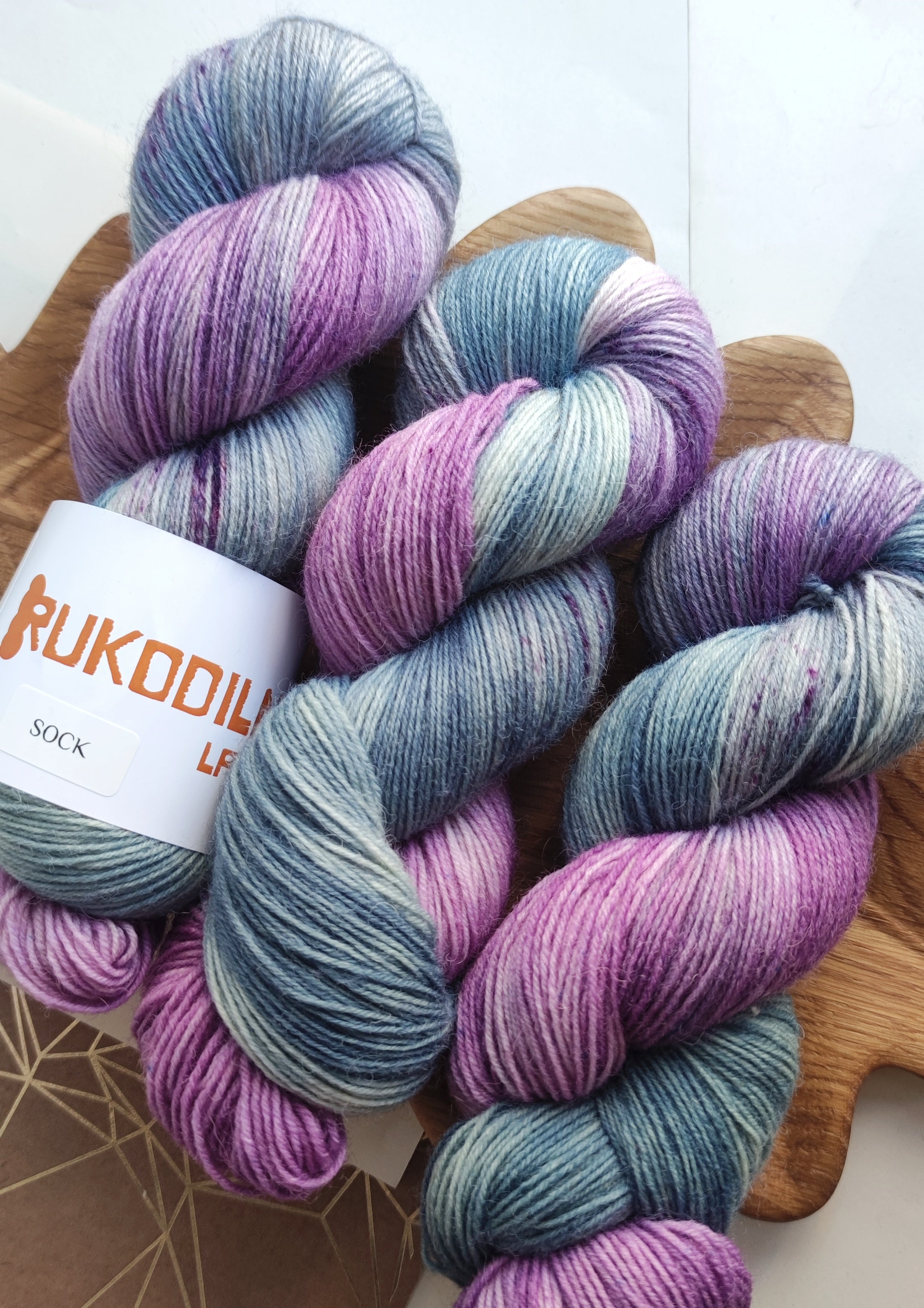 Hand dyed sock yarn in soft lavender and sage tones, made from superwash merino wool and nylon, ideal for knitting socks, shawls, and everyday knitwear.