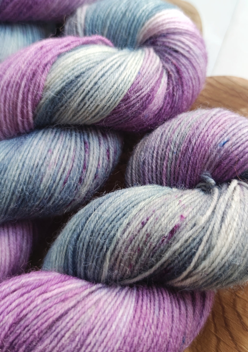 Hand dyed sock yarn in soft lavender and sage tones, made from superwash merino wool and nylon, ideal for knitting socks, shawls, and everyday knitwear.