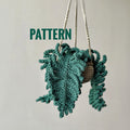 Crochet fern hanging plant pattern with textured green fern leaves and hanging cords on a neutral background.