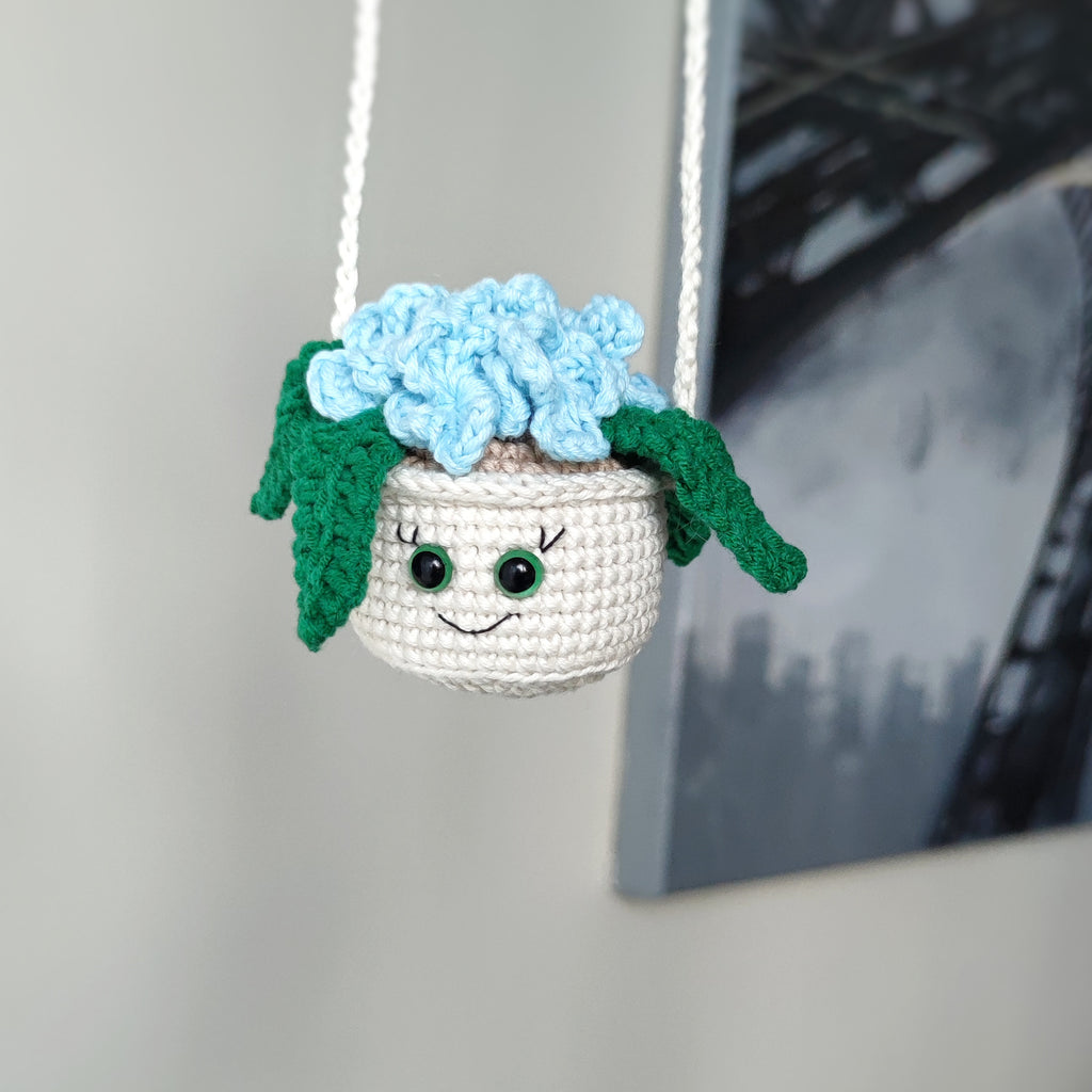 Crochet hanging flower pot with smiling face and blue flowers, handmade amigurumi decor pattern