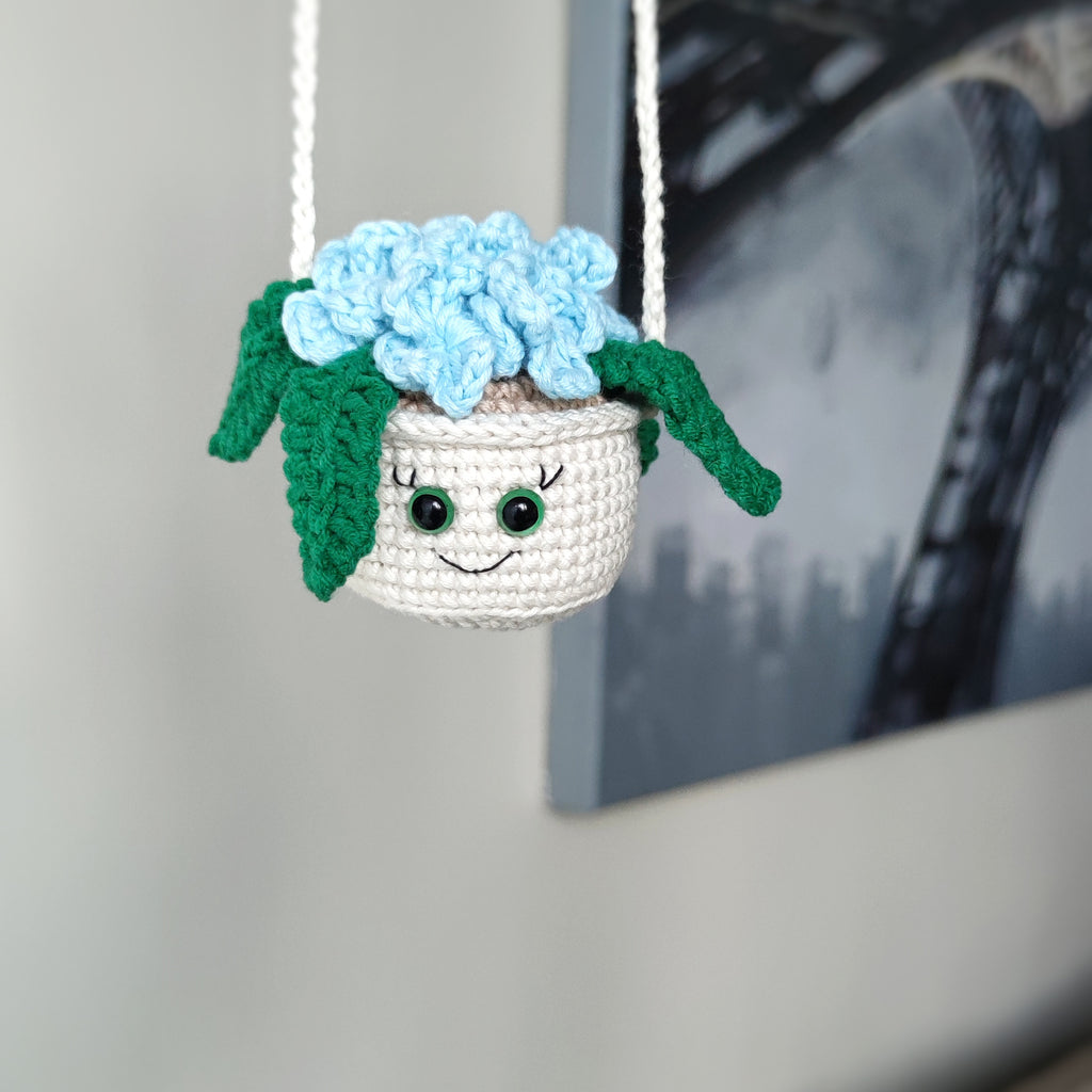 Crochet hanging flower pot with smiling face and blue flowers, handmade amigurumi decor pattern