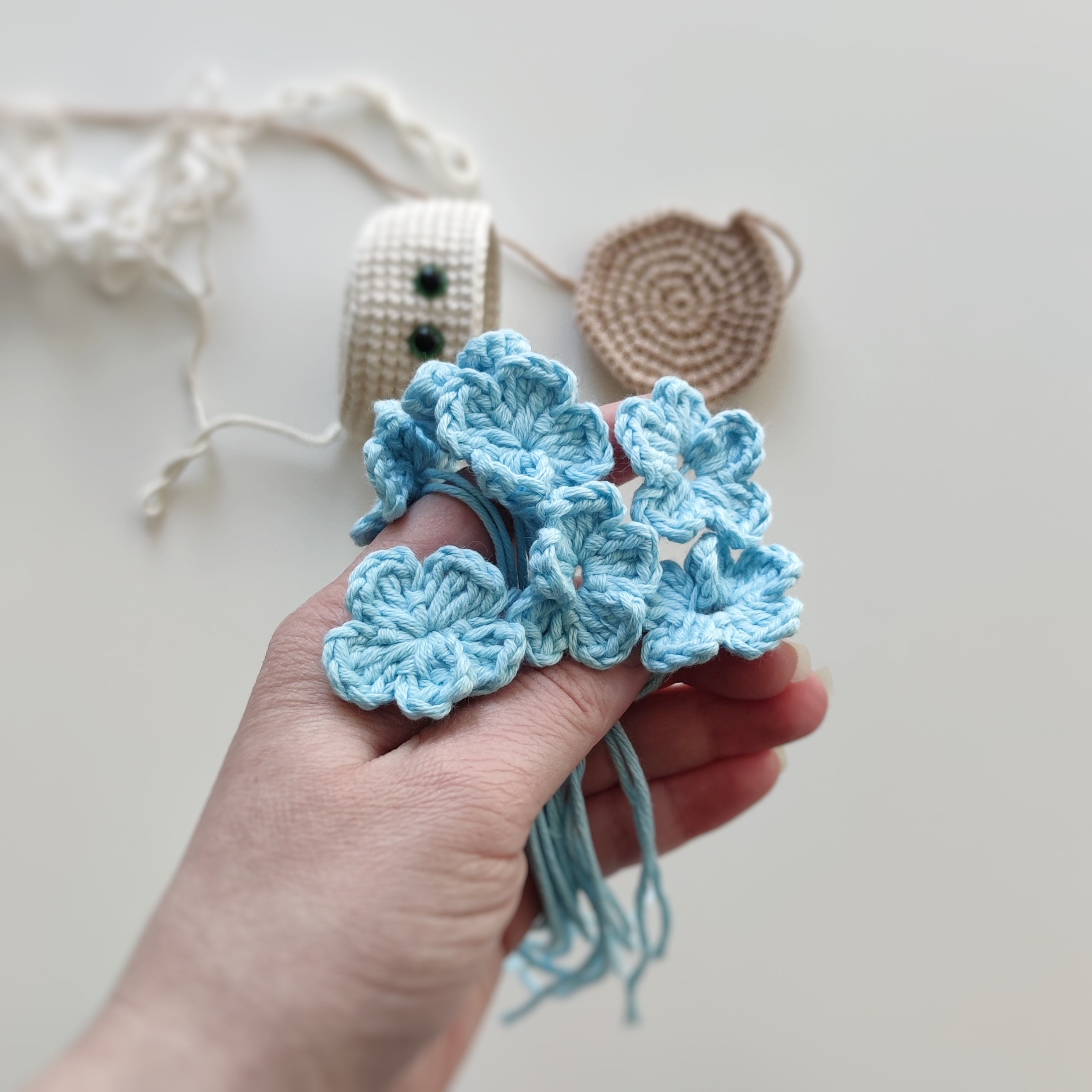 Crochet hanging flower pot with smiling face and blue flowers, handmade amigurumi decor pattern