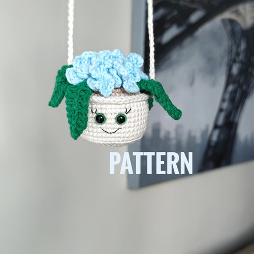 Crochet hanging flower pot with smiling face and blue flowers, handmade amigurumi decor pattern