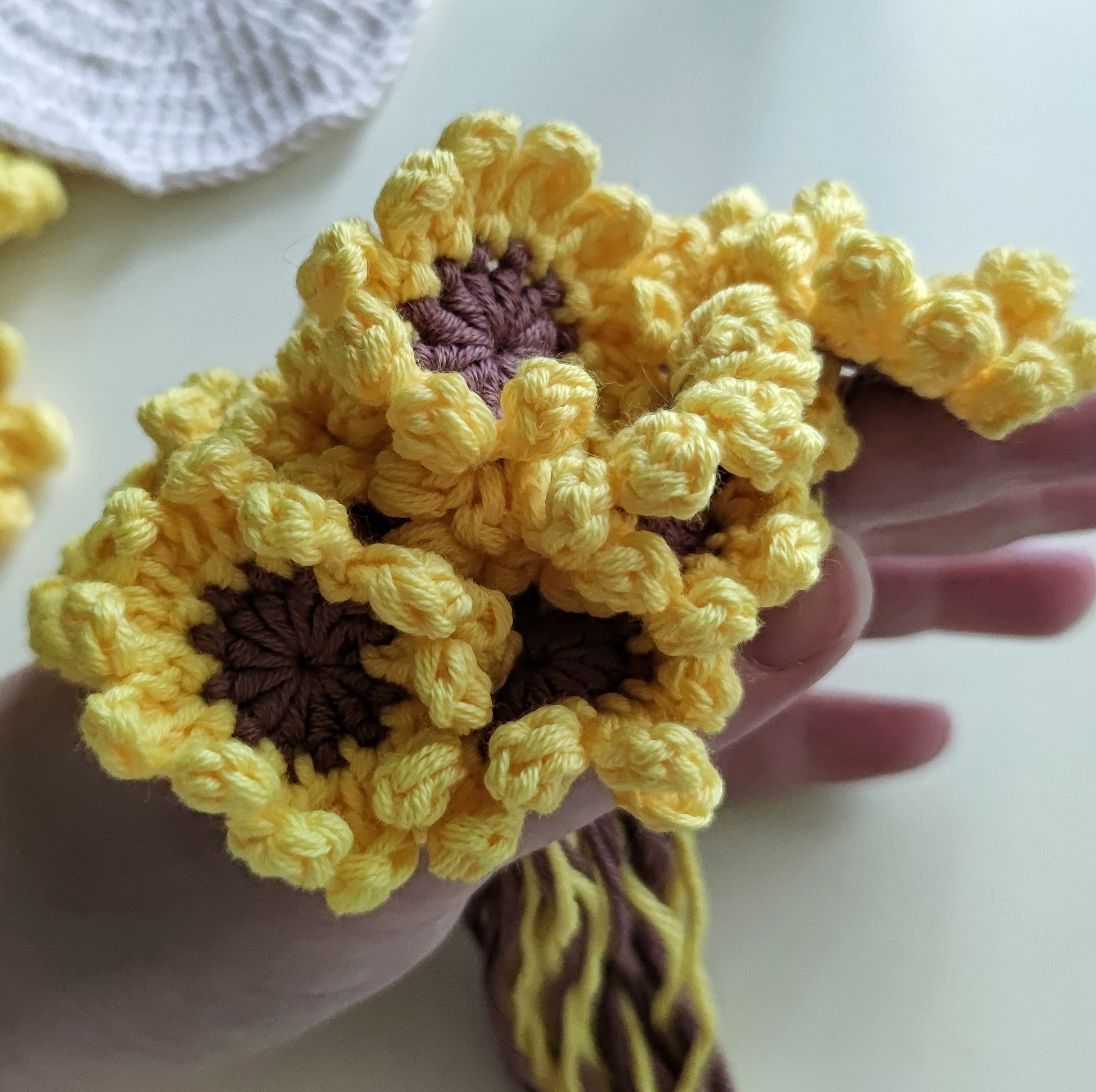Sunflower crochet coasters with textured petal clusters, pattern example shown.