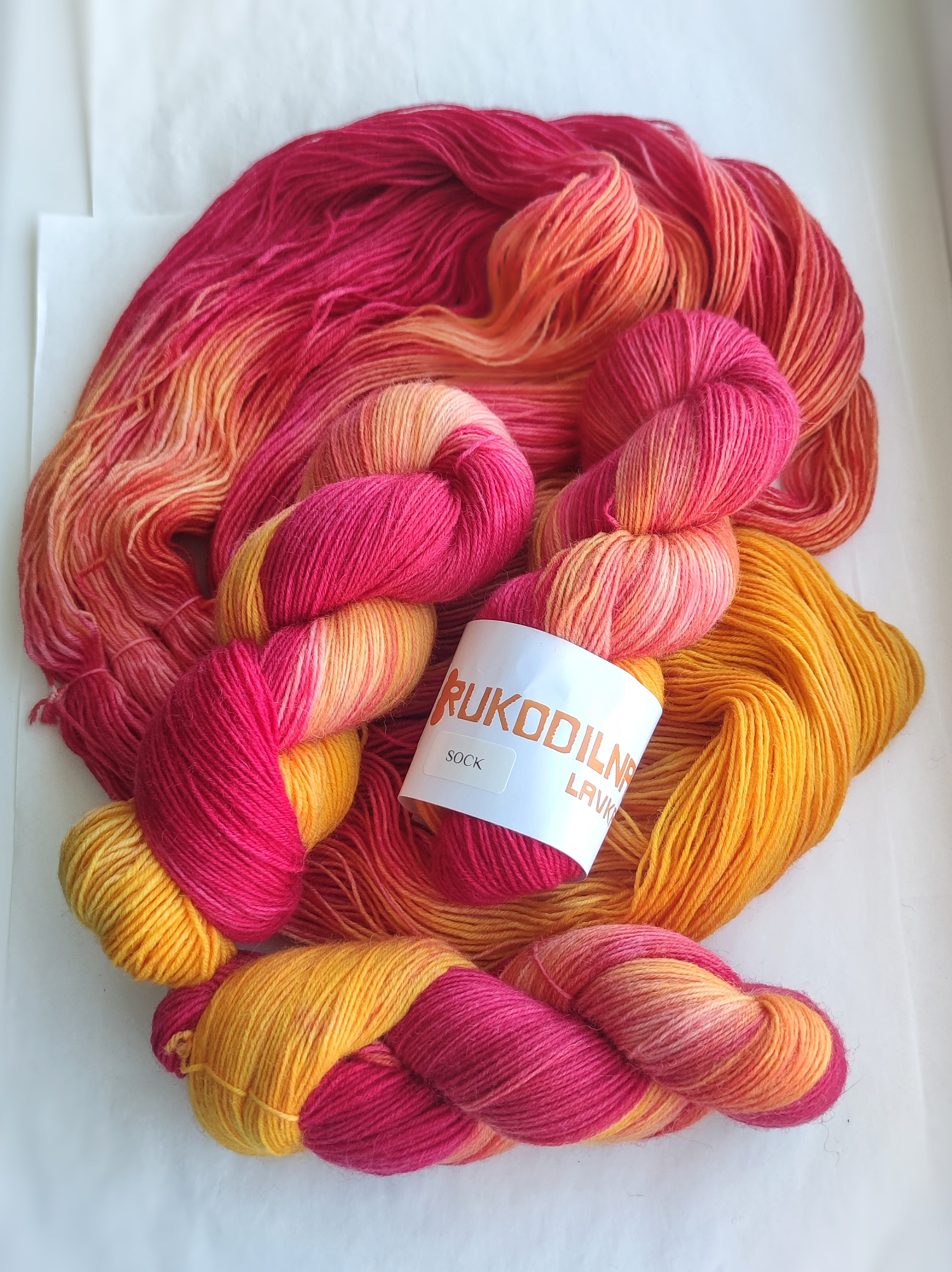 Hand dyed pink orange variegated sock yarn skeins with bright floral inspired color palette