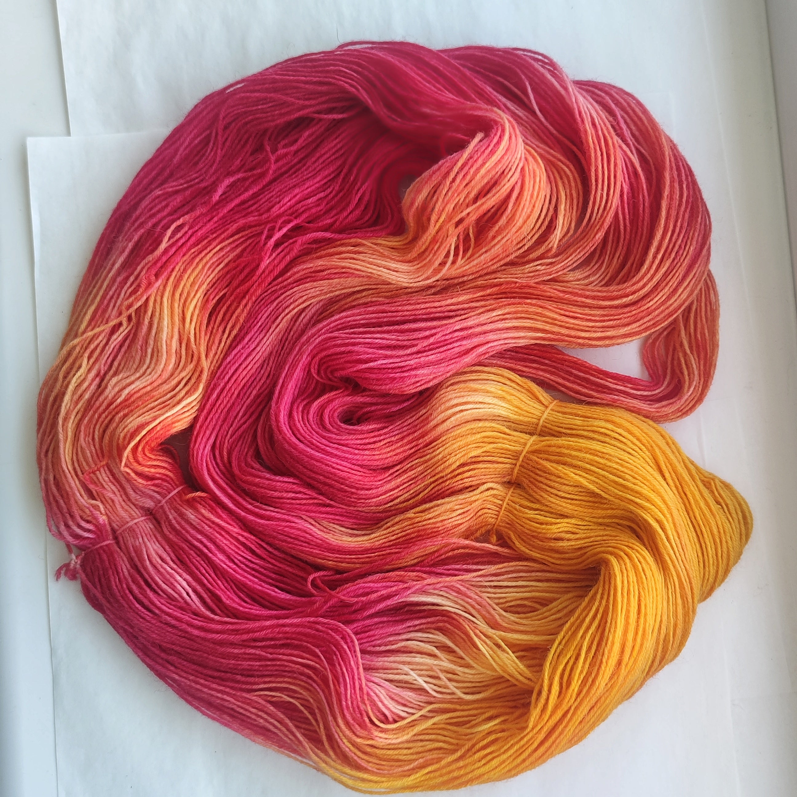 Hand dyed sock yarn set with hot pink, coral and bright orange full skein paired with two coordinating mini skeins for colorful sock knitting projects.