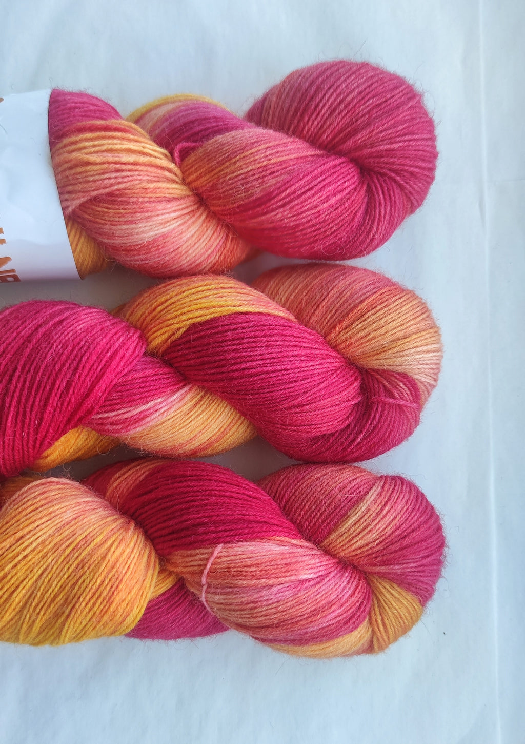 Hand dyed pink orange variegated sock yarn skeins with bright floral inspired color palette