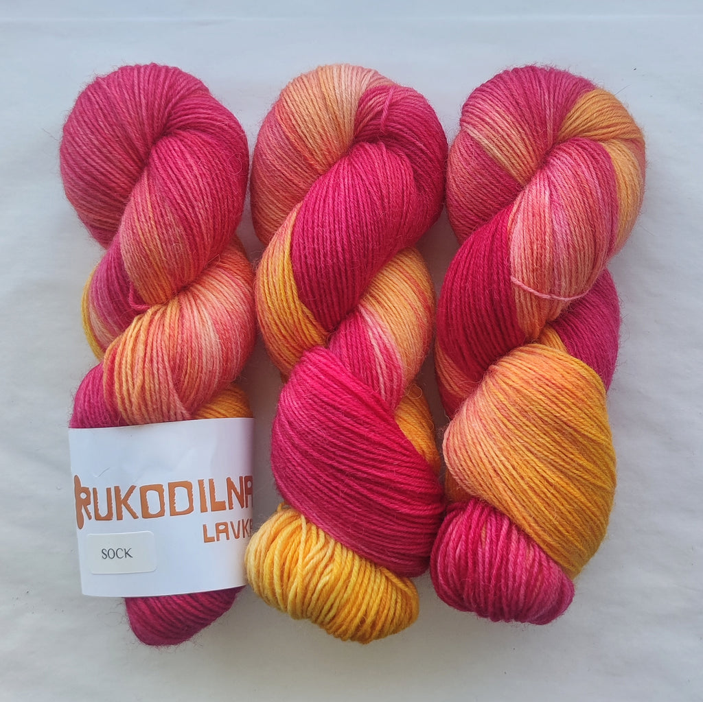 Hand dyed pink orange variegated sock yarn skeins with bright floral inspired color palette