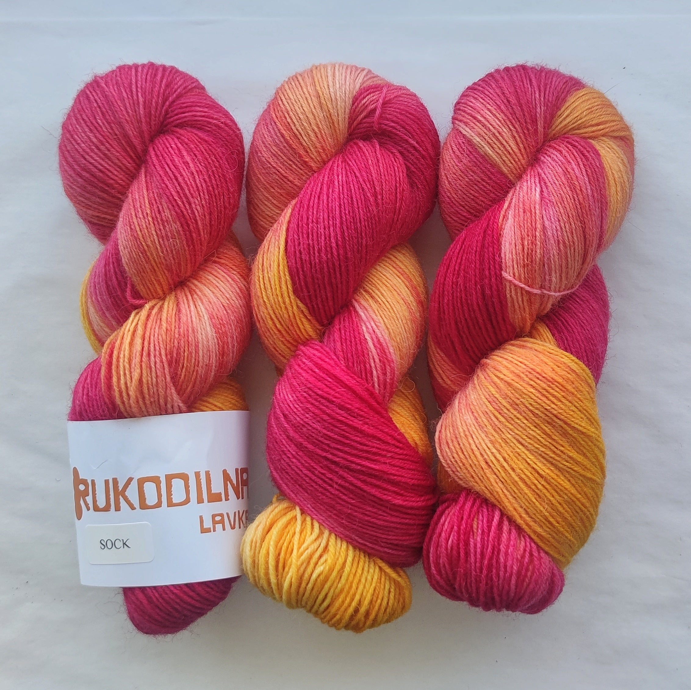 Hand dyed pink orange variegated sock yarn skeins with bright floral inspired color palette