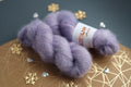 Lavender kid mohair silk yarn skeins on decorative surface