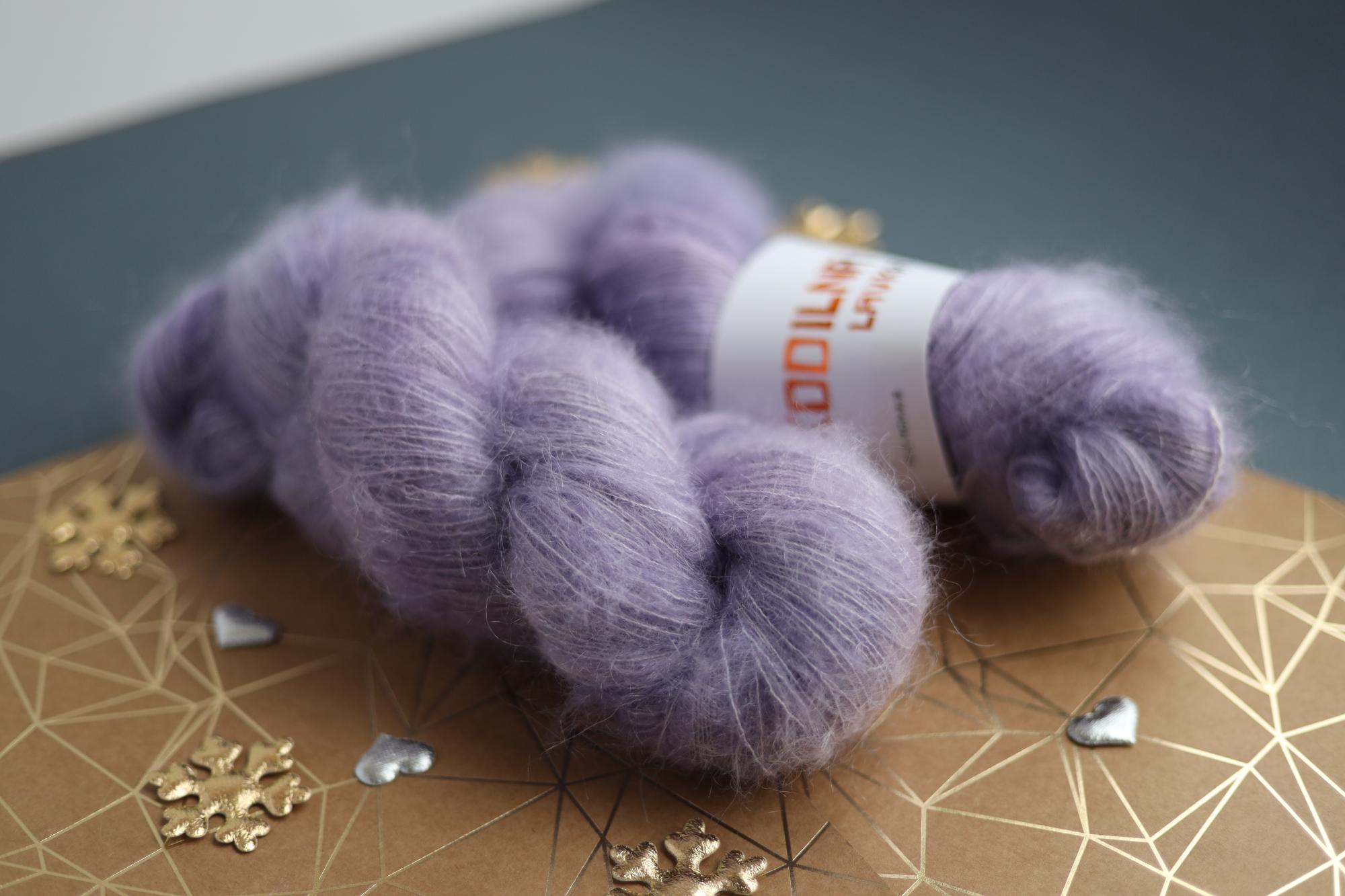 Lavender kid mohair silk yarn skeins on decorative surface