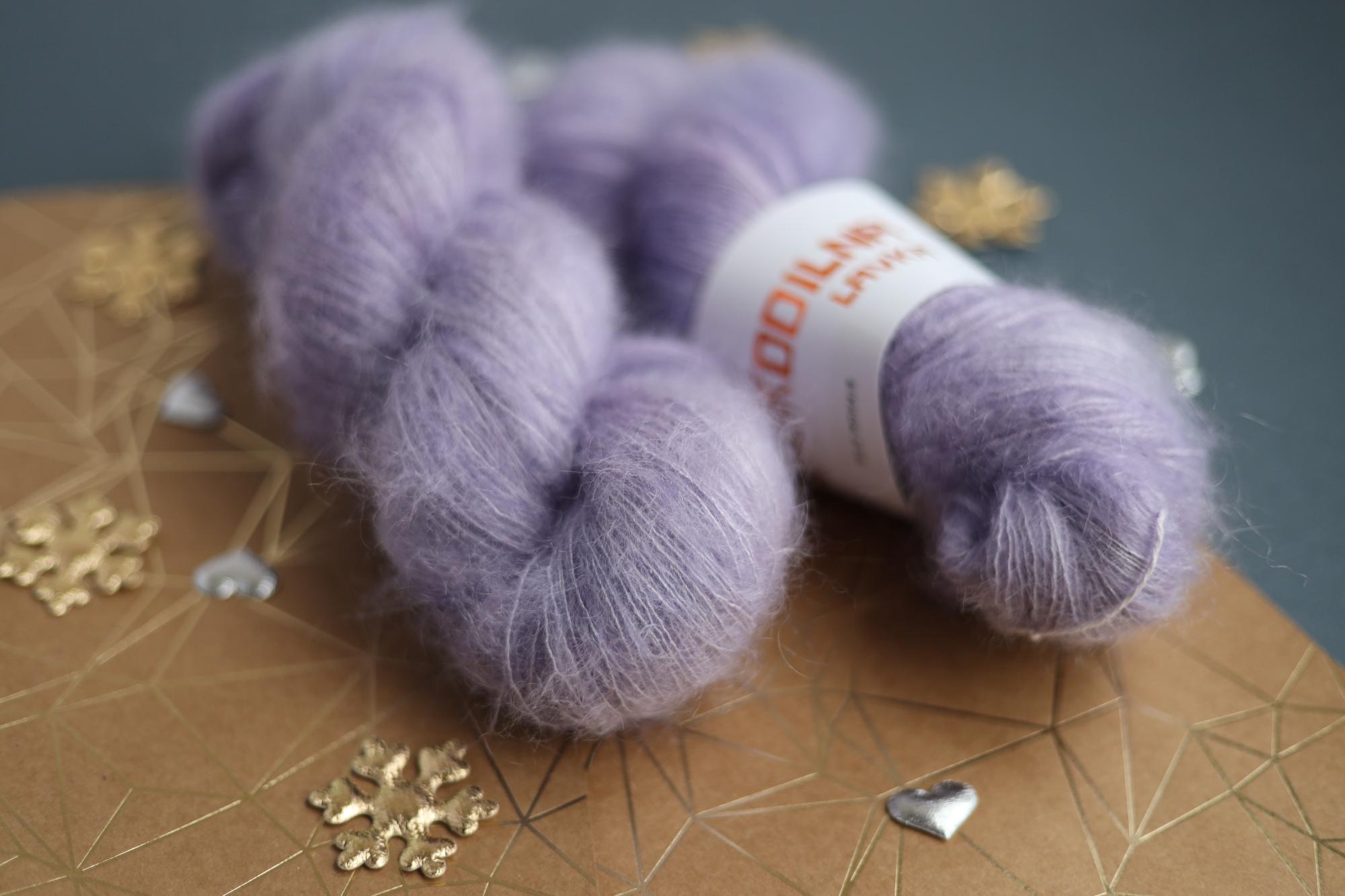 Lavender kid mohair silk yarn skeins on decorative surface