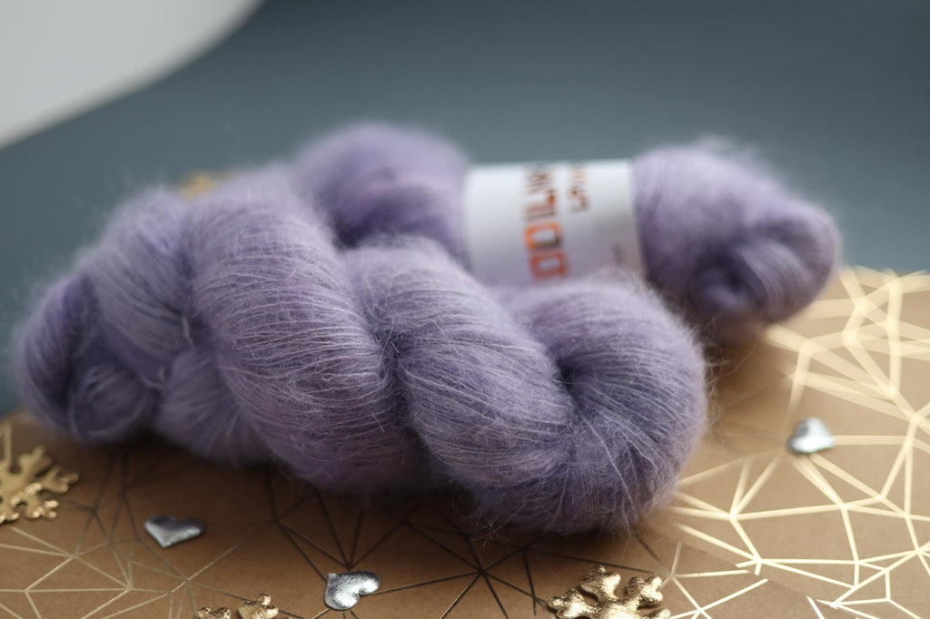 Lavender kid mohair silk yarn skeins on decorative surface