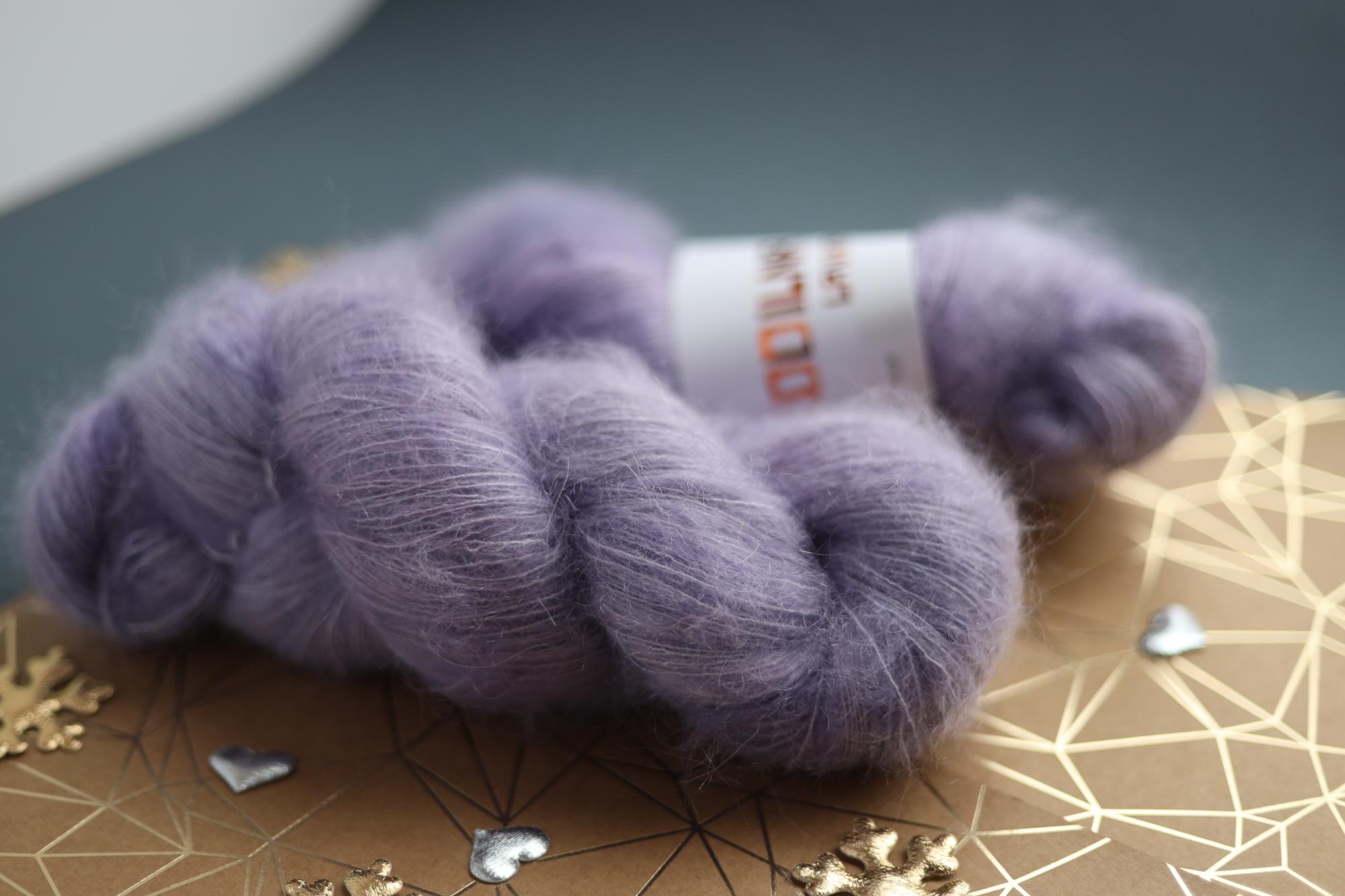 Lavender kid mohair silk yarn skeins on decorative surface