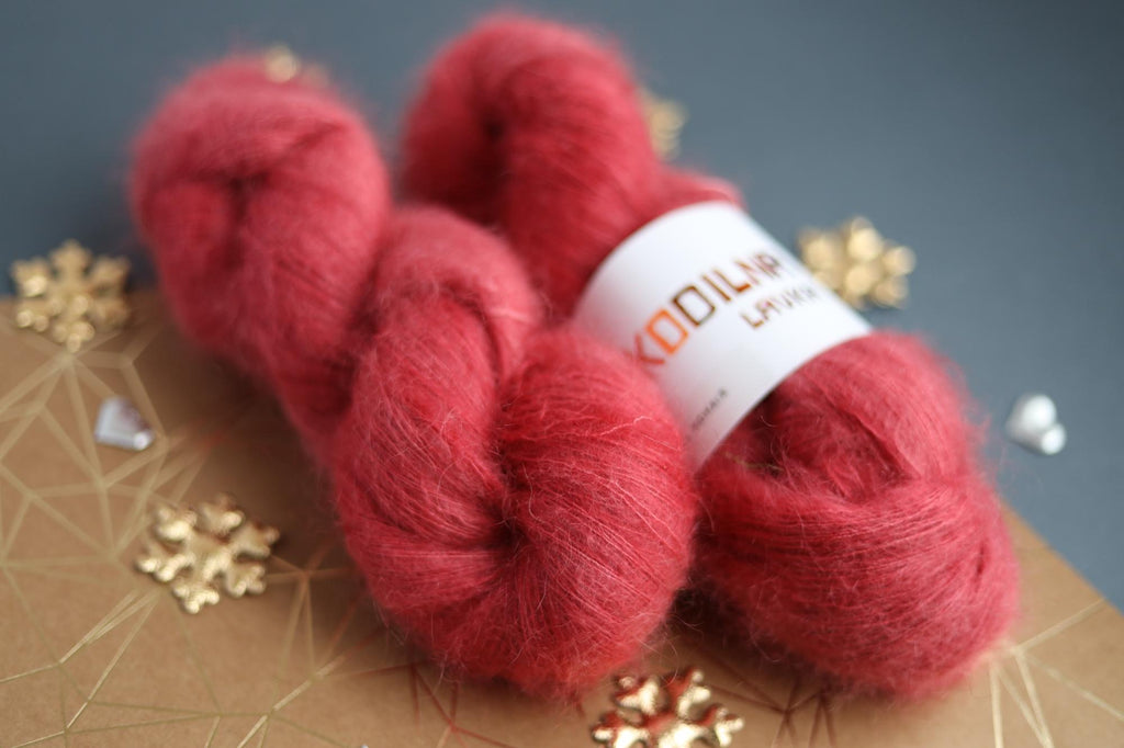 Ruby red kid mohair silk yarn skeins on decorative background