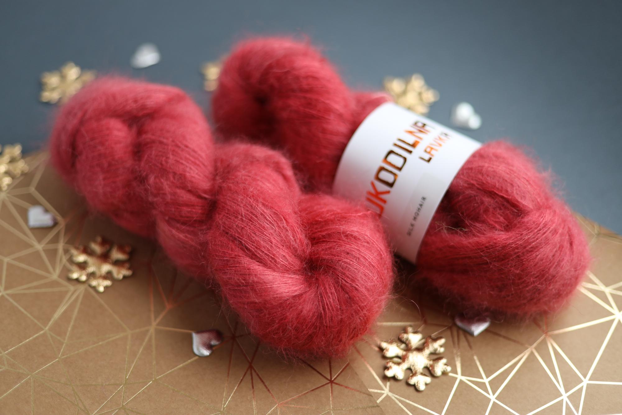 Ruby red kid mohair silk yarn skeins on decorative background
