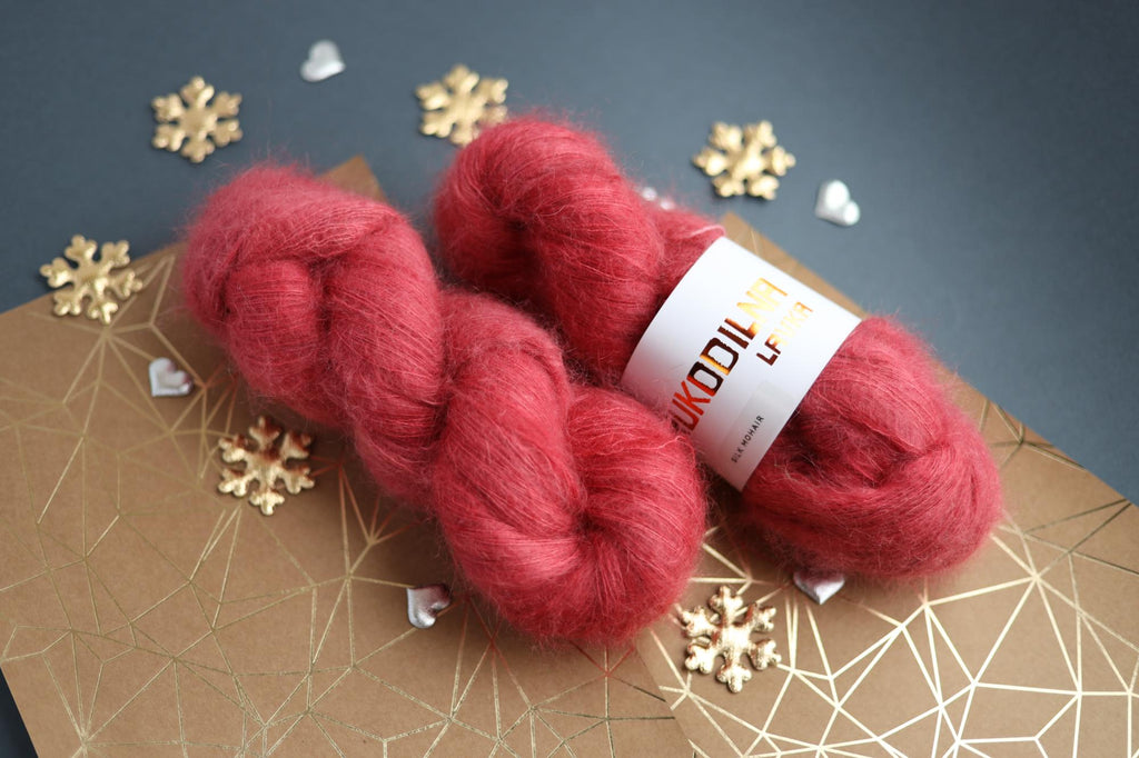 Ruby red kid mohair silk yarn skeins on decorative background