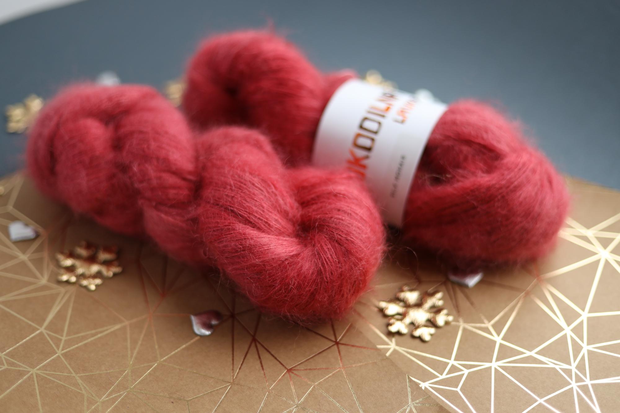 Ruby red kid mohair silk yarn skeins on decorative background