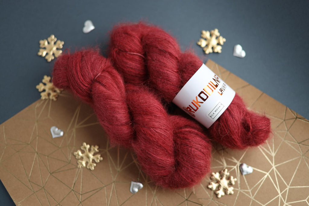 Hand-dyed ruby red silk mohair yarn skein close-up showing airy lace weight texture
