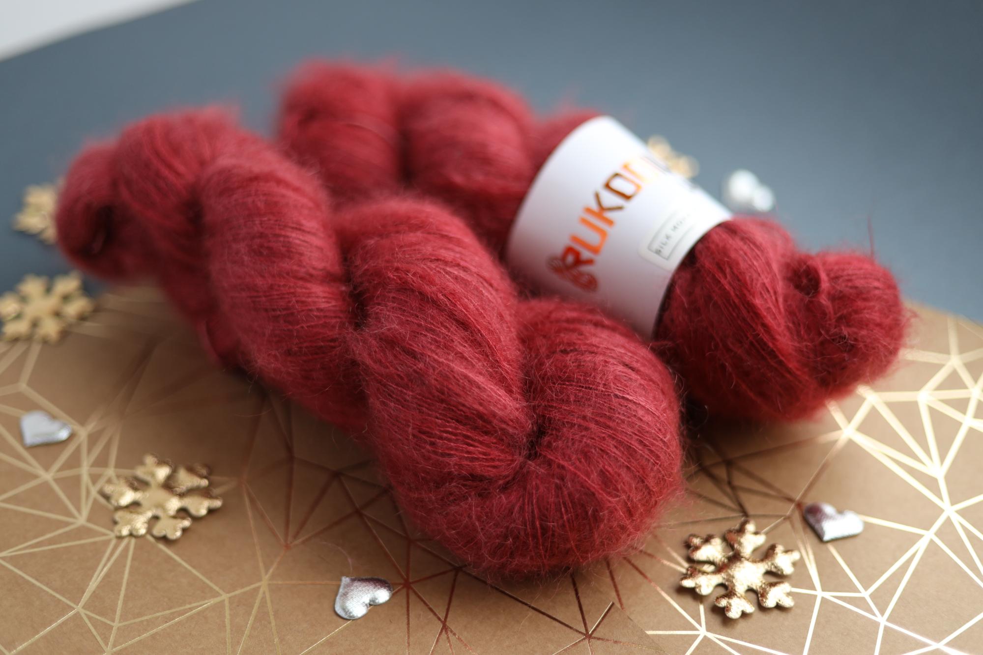 Hand-dyed ruby red silk mohair yarn skein close-up showing airy lace weight texture