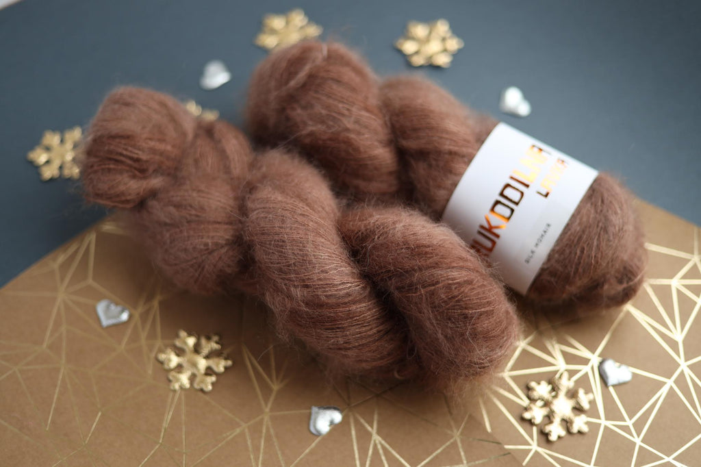 Three skeins of hand-dyed brown kid mohair silk yarn showing fluffy halo texture
