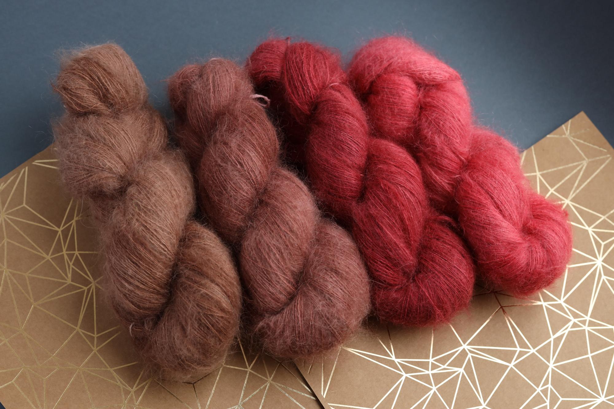 Ruby red kid mohair silk yarn skeins on decorative background