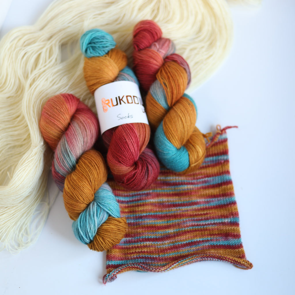 Hand dyed rust and teal sock yarn made from Italian superwash wool with knitted sock swatch, fingering weight 4-ply yarn dyed in Ukraine