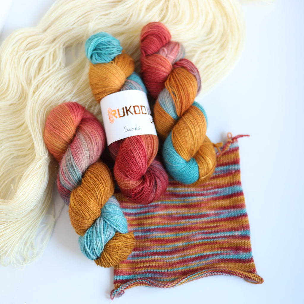 Hand dyed rust and teal sock yarn made from Italian superwash wool with knitted sock swatch, fingering weight 4-ply yarn dyed in Ukraine
