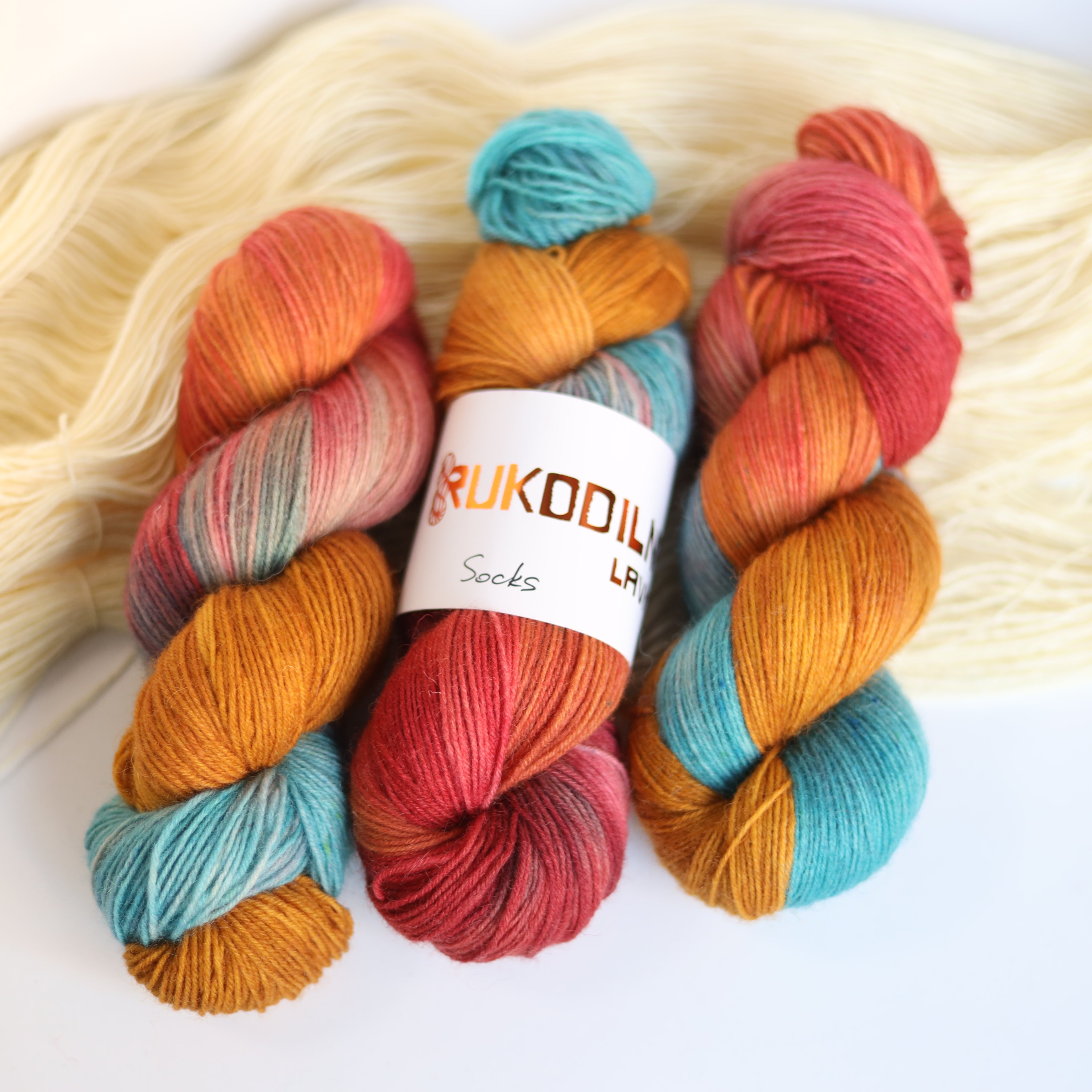 Hand dyed rust and teal sock yarn made from Italian superwash wool with knitted sock swatch, fingering weight 4-ply yarn dyed in Ukraine