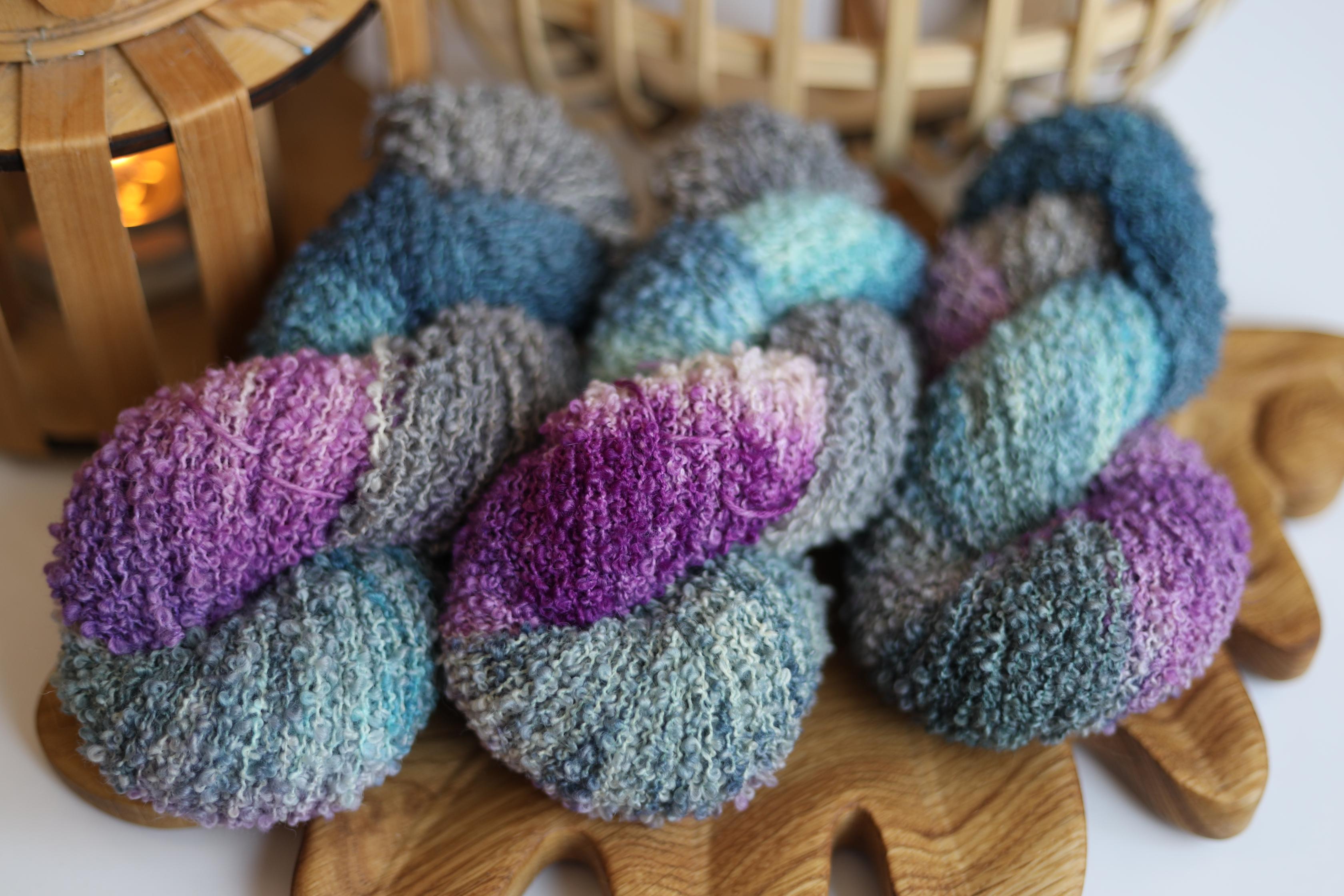 Hand dyed purple blue boucle yarn made from merino wool blend with textured fluffy loop structure