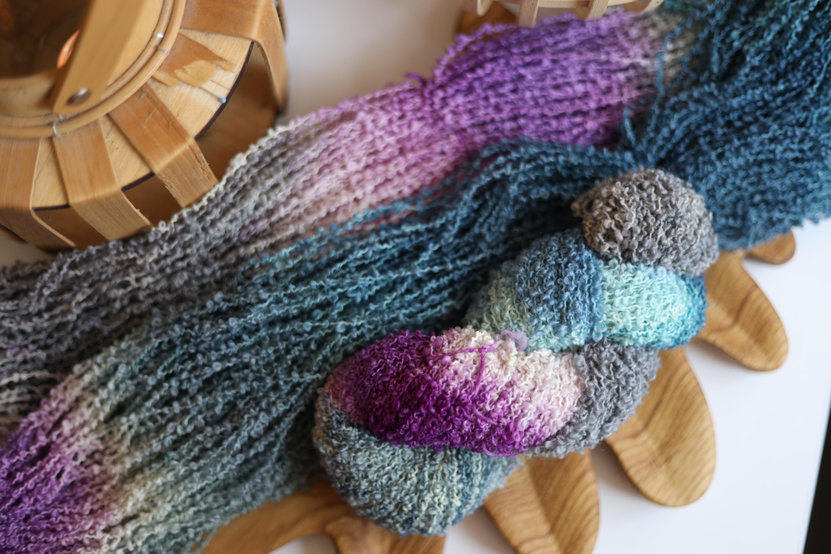 Hand dyed purple blue boucle yarn made from merino wool blend with textured fluffy loop structure