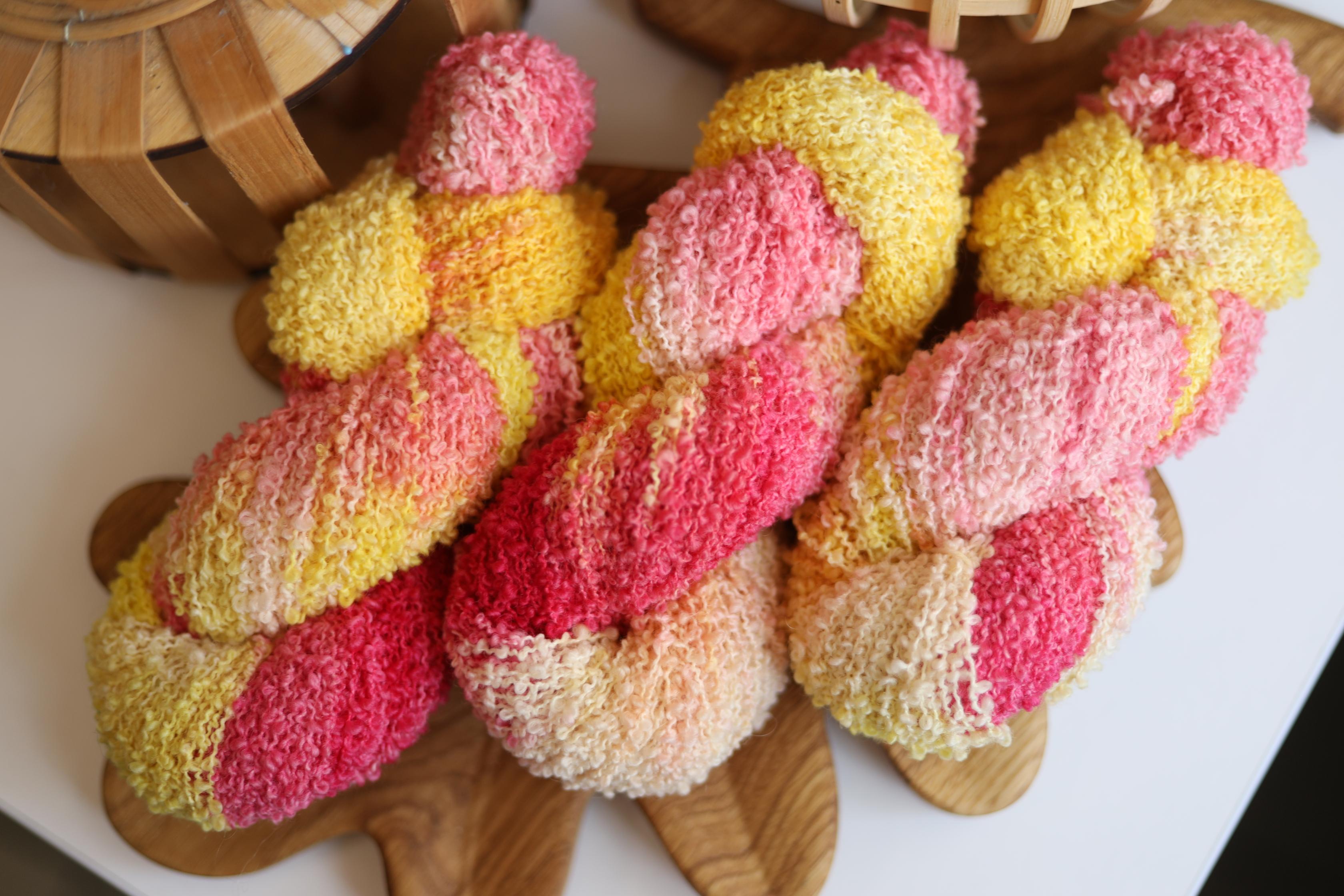 Hand dyed pink yellow boucle yarn made from merino wool blend with soft textured boucle structure
