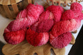 Hand dyed raspberry pink boucle yarn made from merino wool blend with soft textured boucle structure