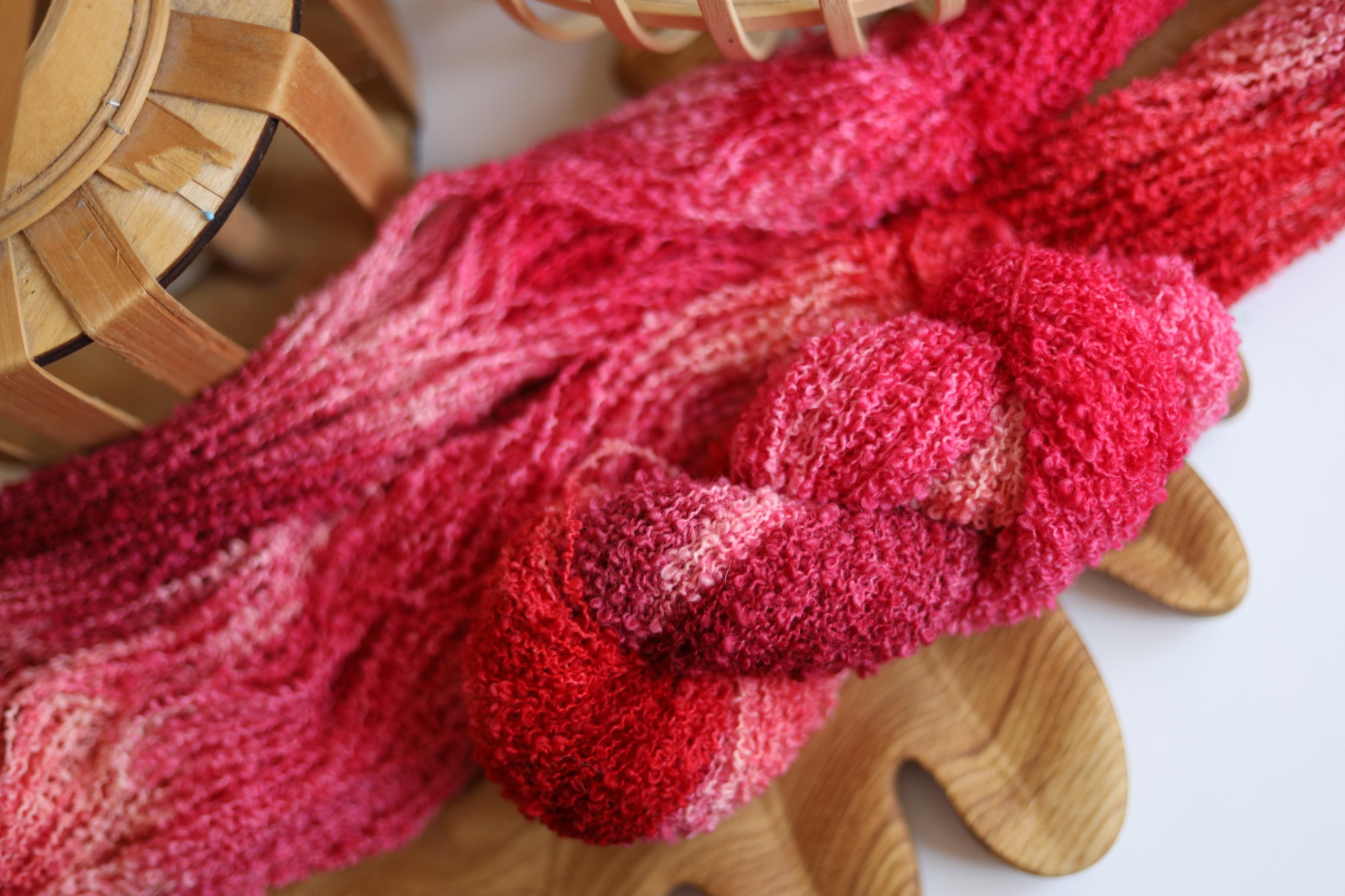 Hand dyed raspberry pink boucle yarn made from merino wool blend with soft textured boucle structure