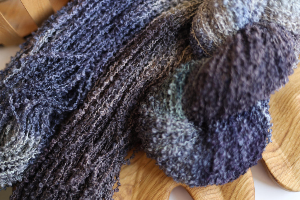 Smoky grey hand dyed boucle yarn made from merino wool blend with textured fluffy loop structure