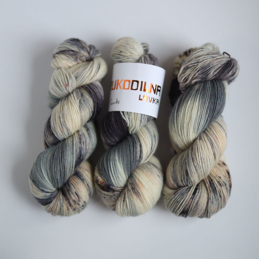 Hand dyed fingering weight sock yarn skein on knitted fabric, variegated wool yarn for socks