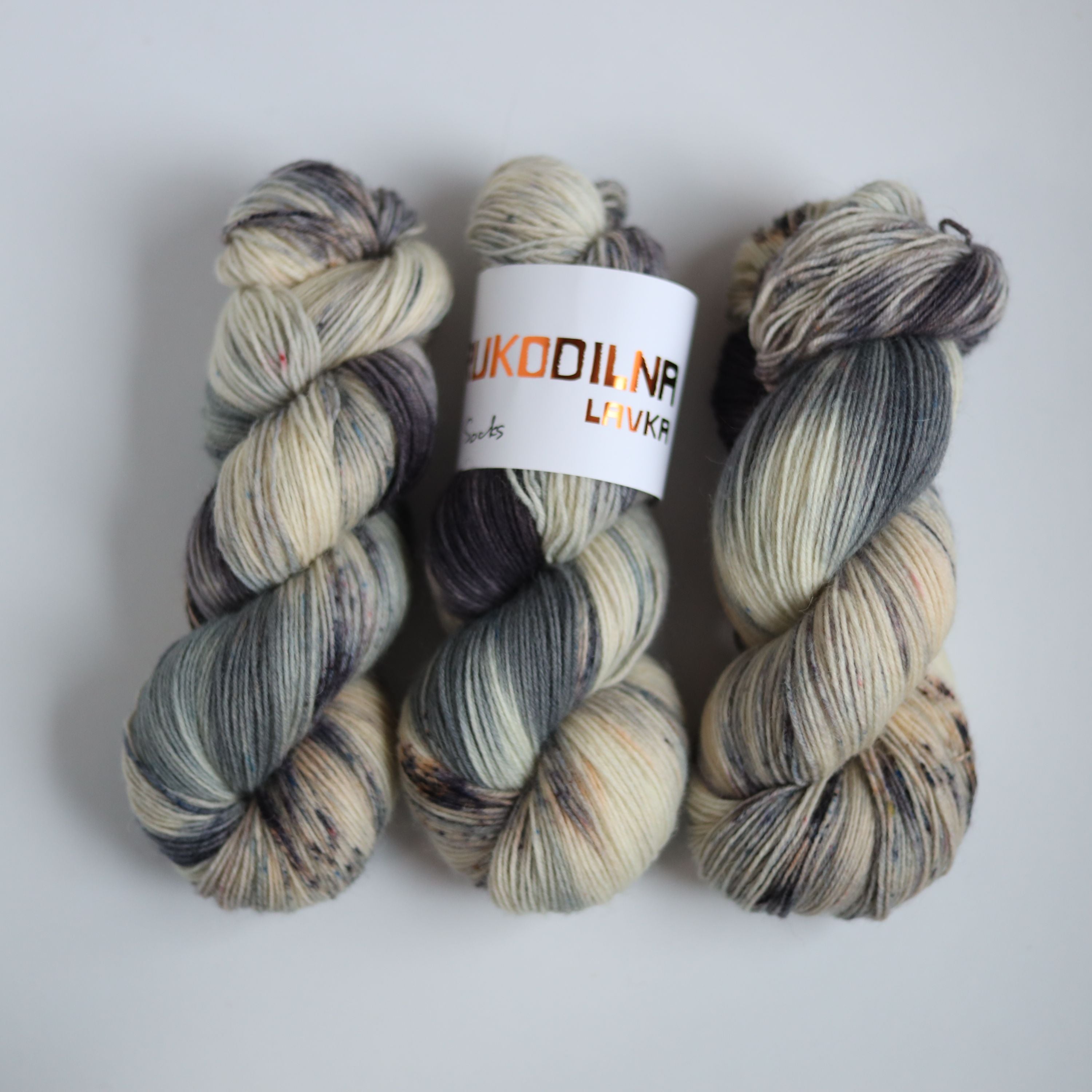 Hand dyed fingering weight sock yarn skein on knitted fabric, variegated wool yarn for socks