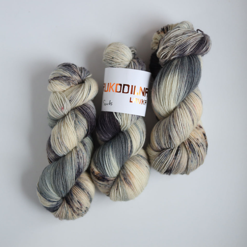 Hand dyed fingering weight sock yarn skein on knitted fabric, variegated wool yarn for socks