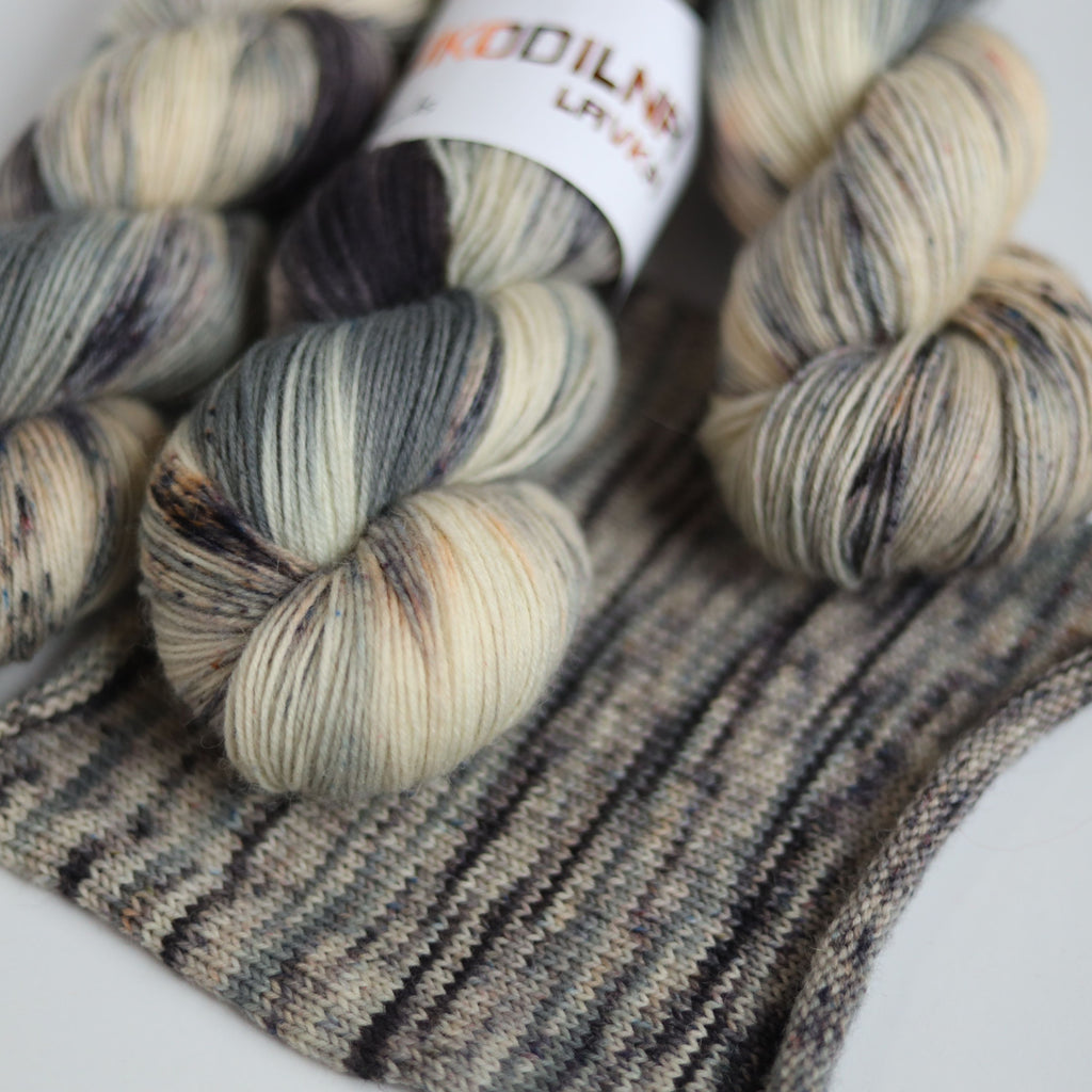 Hand dyed fingering weight sock yarn skein on knitted fabric, variegated wool yarn for socks