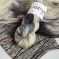 Hand dyed fingering weight sock yarn skein on knitted fabric, variegated wool yarn for socks