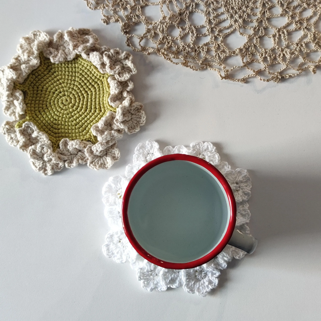 Flower crochet coaster with ruffled edge under coffee mug