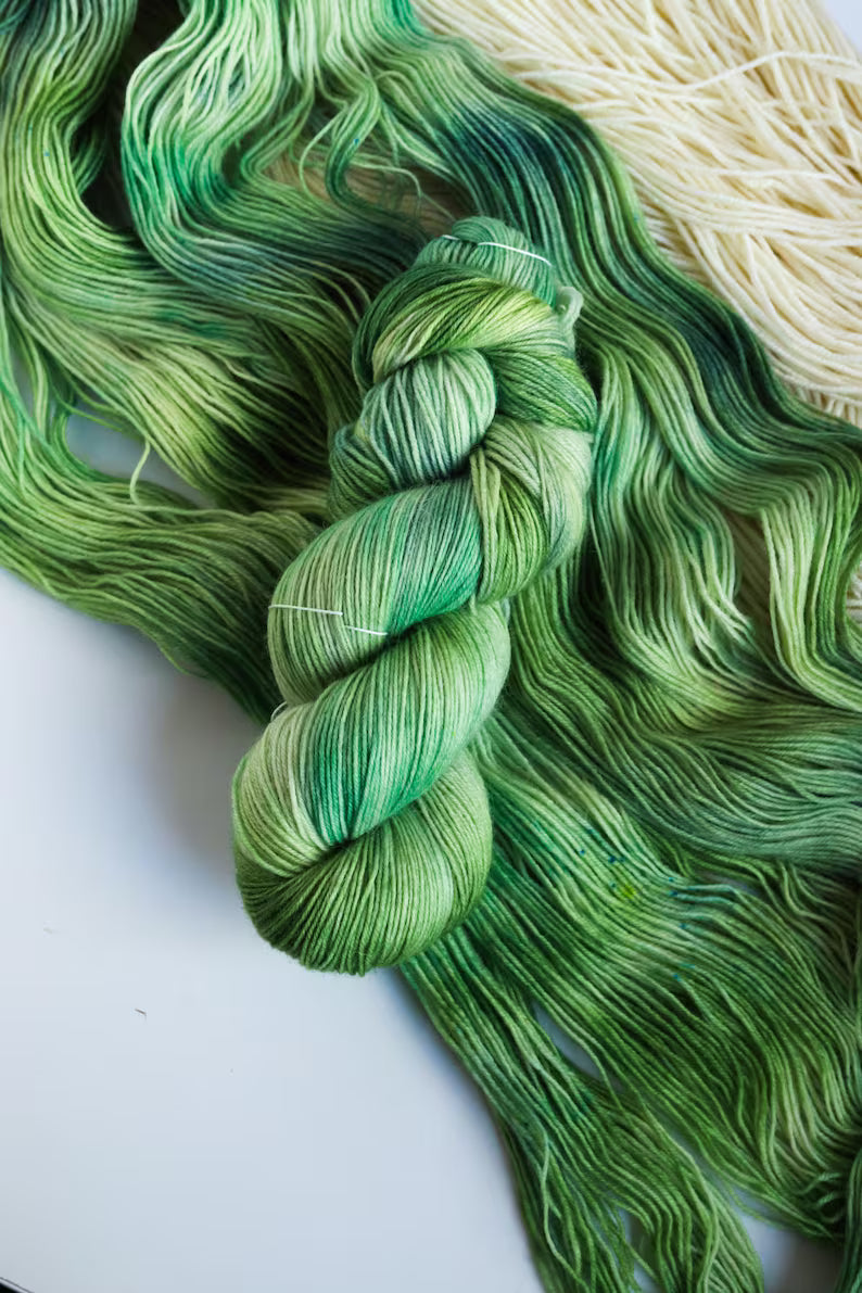 Hand dyed sock yarn in forest green shades with sage, moss, mint and pine green color transitions on a superwash wool nylon base