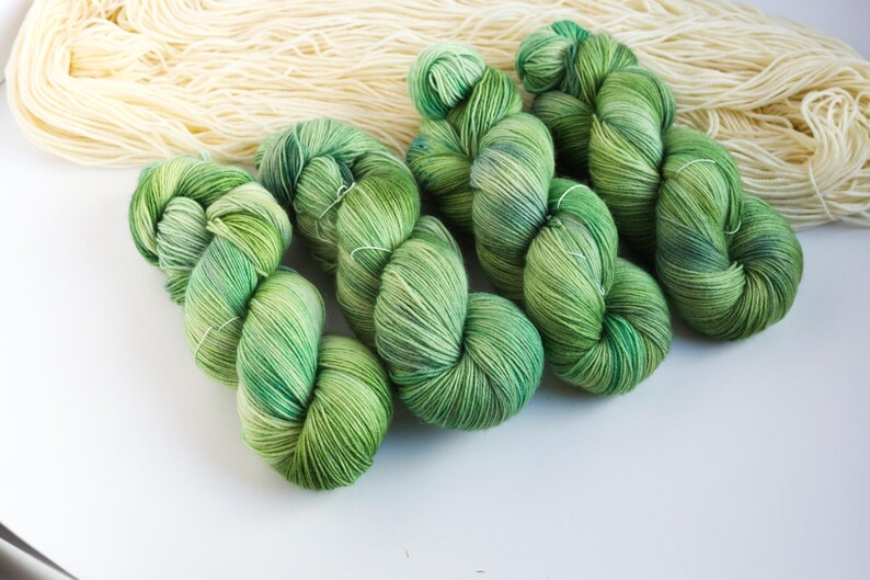 Hand dyed sock yarn in forest green shades with sage, moss, mint and pine green color transitions on a superwash wool nylon base