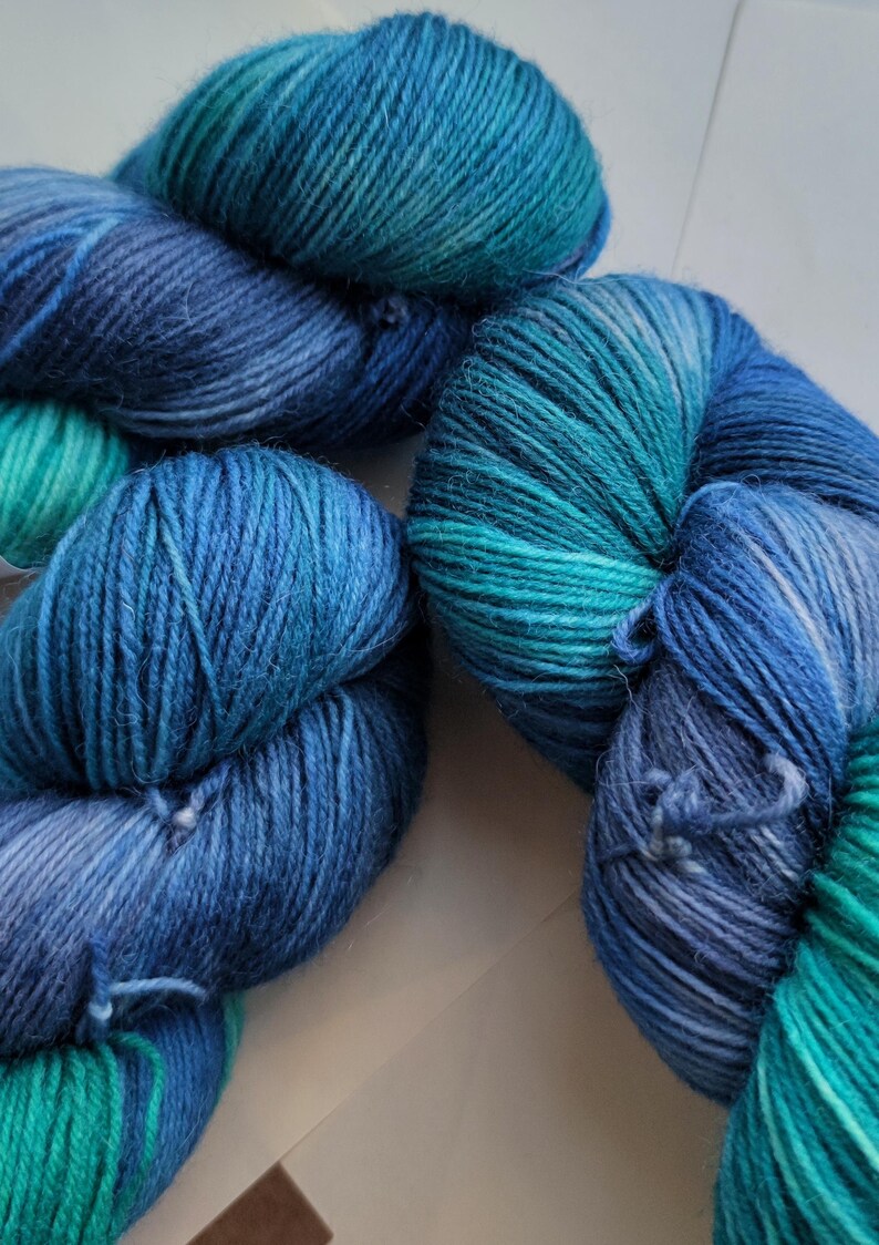 Hand dyed sock yarn in ocean blue, teal and smoky grey shades, superwash merino wool nylon fingering weight yarn for knitting socks, shawls and sweaters.