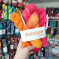 Hand dyed sock yarn set with hot pink, coral and bright orange full skein paired with two coordinating mini skeins for colorful sock knitting projects.